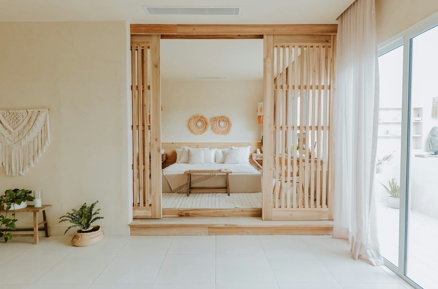 Boho woonkamer met macramé wanddecoratie, rotan meubels en weelderige groene planten