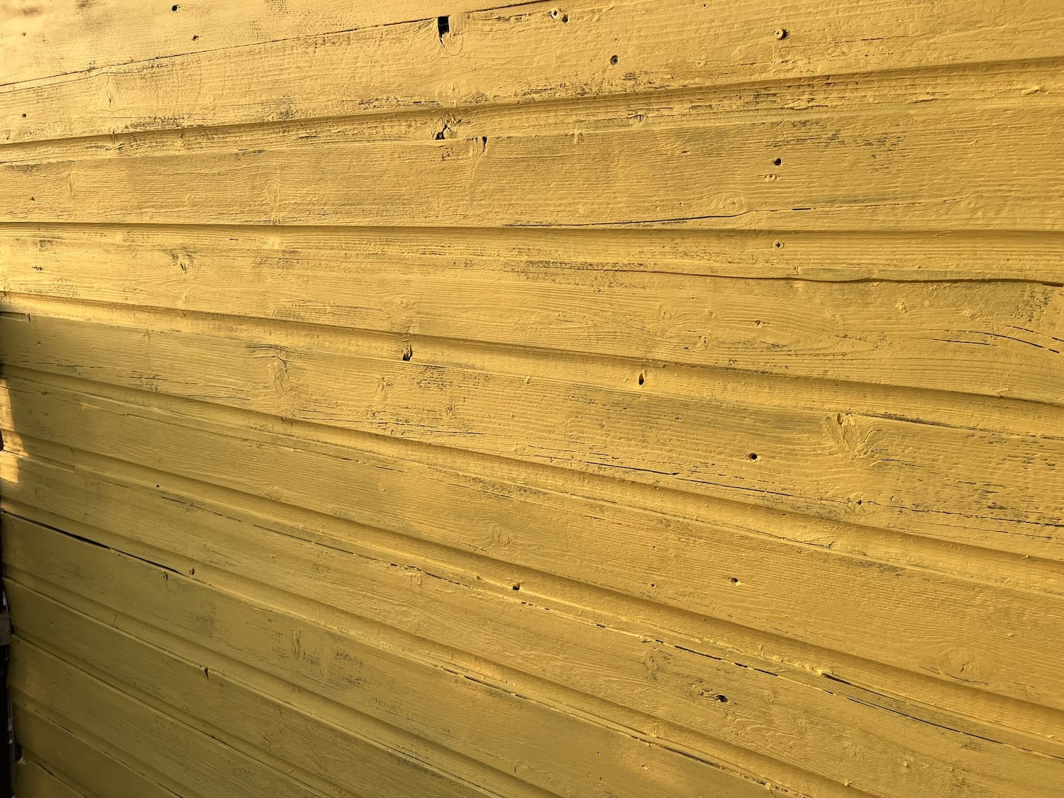 Schutting na het verven in een frisse kleur, met zichtbaar vernieuwd resultaat