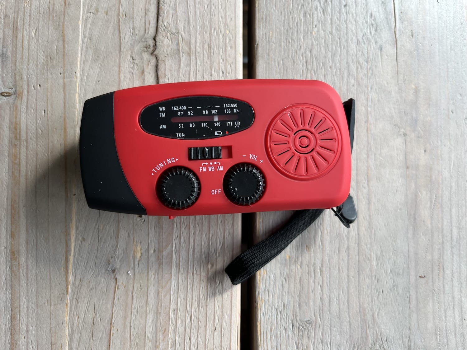 Zijkant van de solar noodradio met de zwengel (crank) voor handmatig opladen