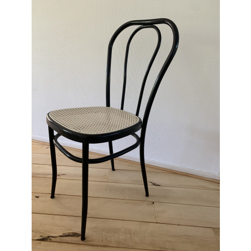 Zwarte stoel met rotan zitting afbeelding